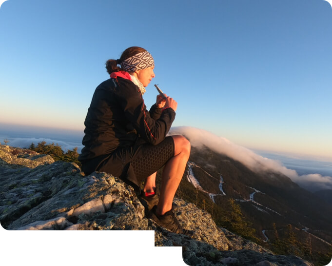 An athlete eating UnTapped Syrup on top of a mountain